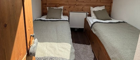 Un dormitorio con dos camas, un tragaluz y un radiador.