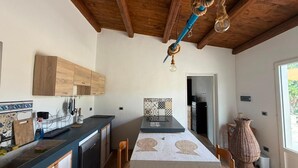 Cozinha moderna com armários de madeira, uma ilha central e luminária pendente.