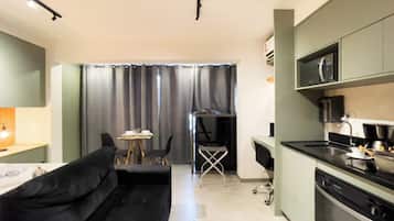 Eine moderne Küche mit Mikrowelle, Kaffeemaschine und einem Essbereich mit Sofa und Stühlen.