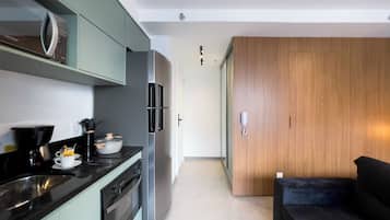 A modern kitchen with a built-in oven, a coffee maker, and a refrigerator.