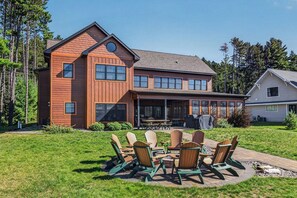 A two-story wooden house with a deck and outdoor seating area.