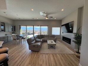 A modern living room with a sectional sofa, a dining area, and a kitchen. - Mesquite 3BR Home | Private Pool + Slide | Free Activities | Views (Mesquite)