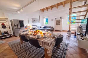 Una cucina moderna con zona pranzo, un frigorifero e un tavolo imbandito per la colazione.