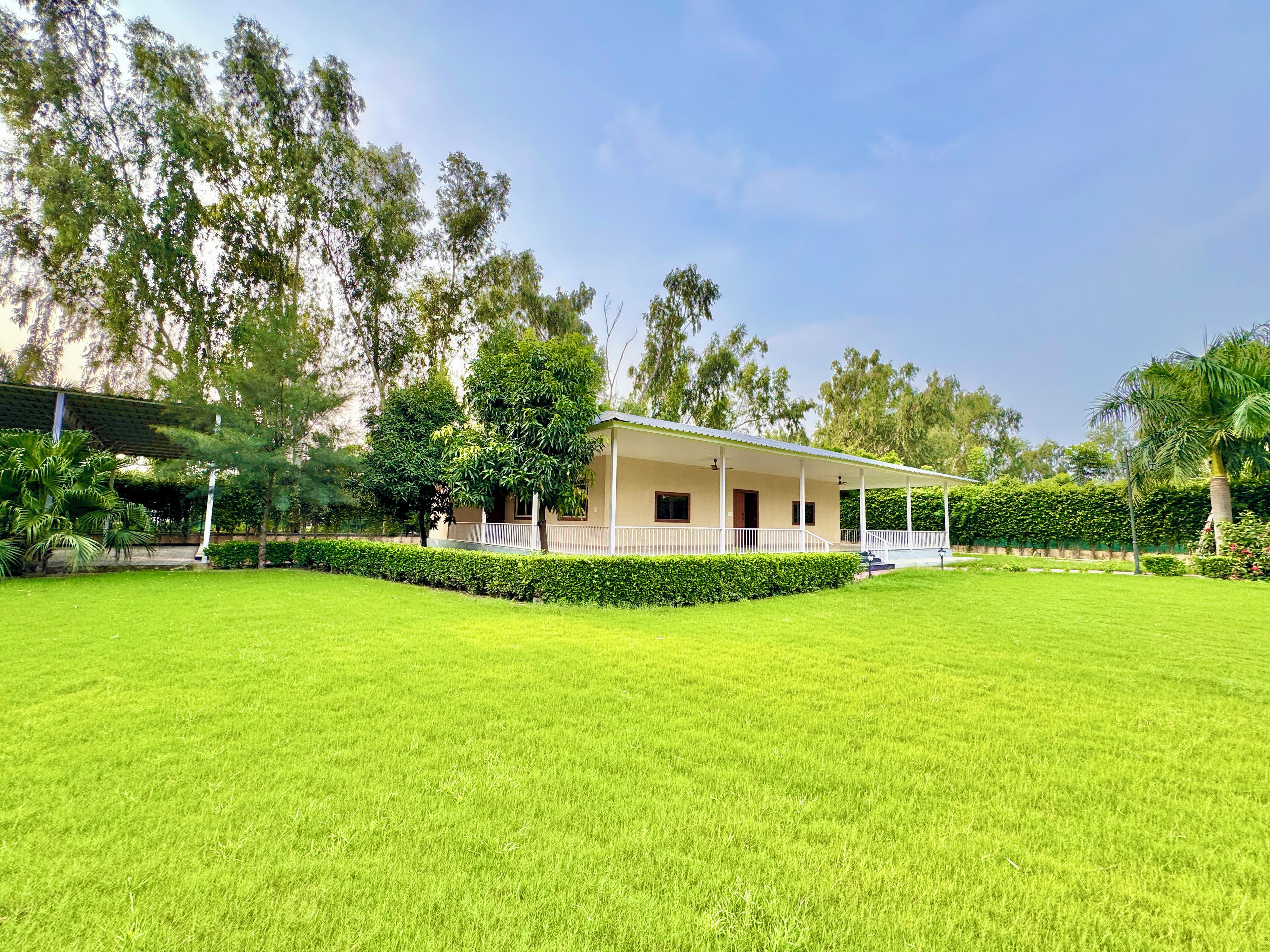 A single-story building with a covered porch, surrounded by a well-maintained lawn and various trees.