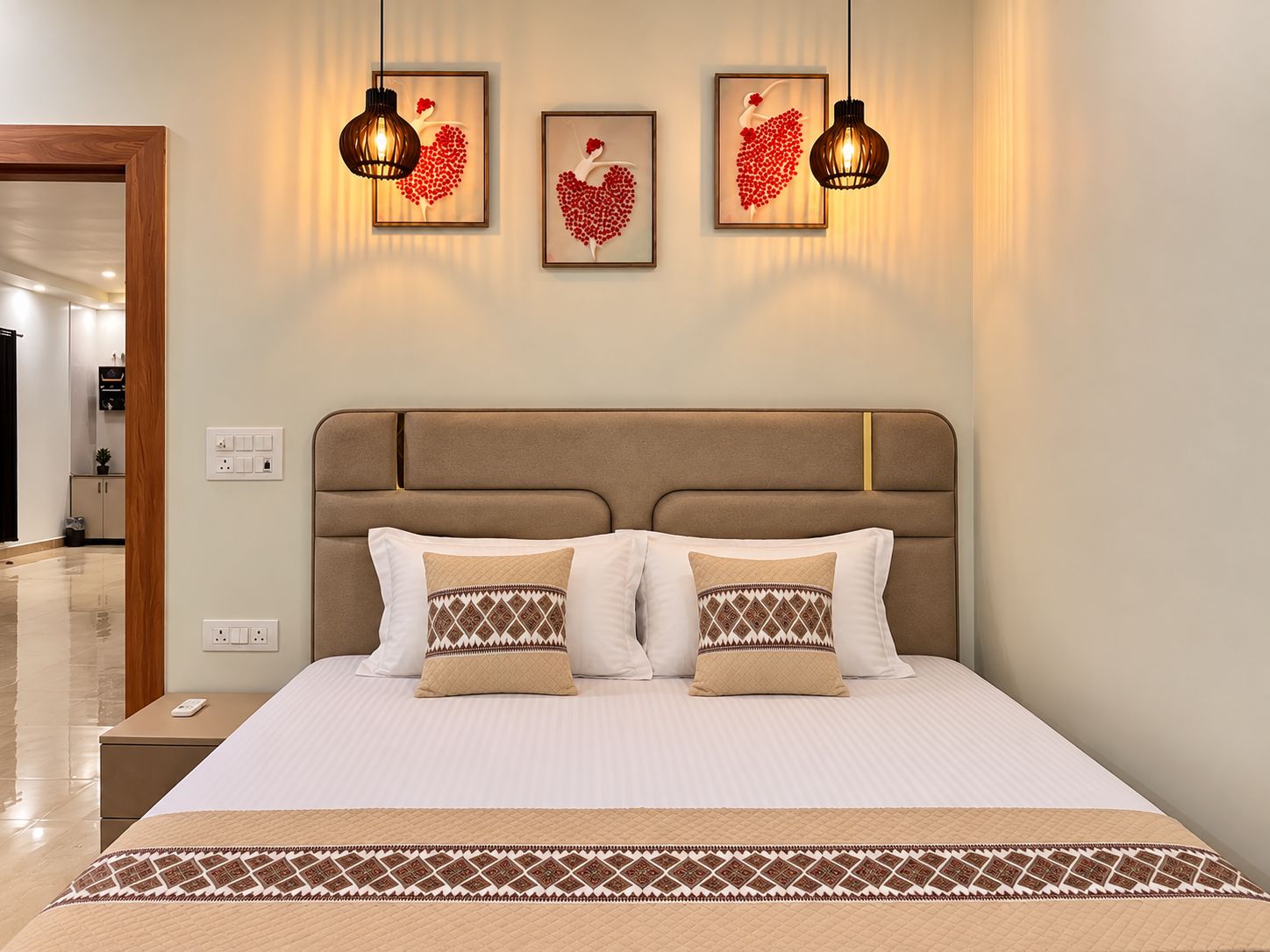 Habitación de hotel con cama, dos mesitas de noche, cabecero y una obra de arte colgada en la pared.