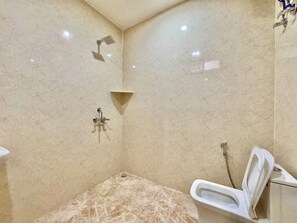 A bathroom with a shower, a toilet, and a sink. - Mulberry Farm (Noida)
