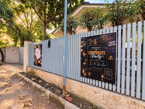 Un área cercada con un cartel de fiesta corporativa y un anuncio de piscina.