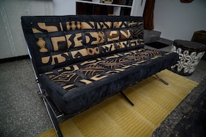 Ein Sofa mit gemustertem Rücken und passendem Kissen auf einem gelben Teppich.