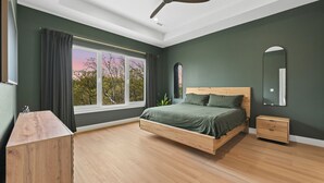 Quarto com cama, mesa de cabeceira e ventoinha no teto.