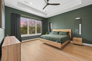 A bedroom with a bed, bedside table, and a ceiling fan. - Trailside MTB Retreat with Sauna (Bella Vista)
