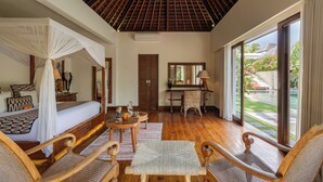 Una habitación con cama, escritorio y vista a la piscina.