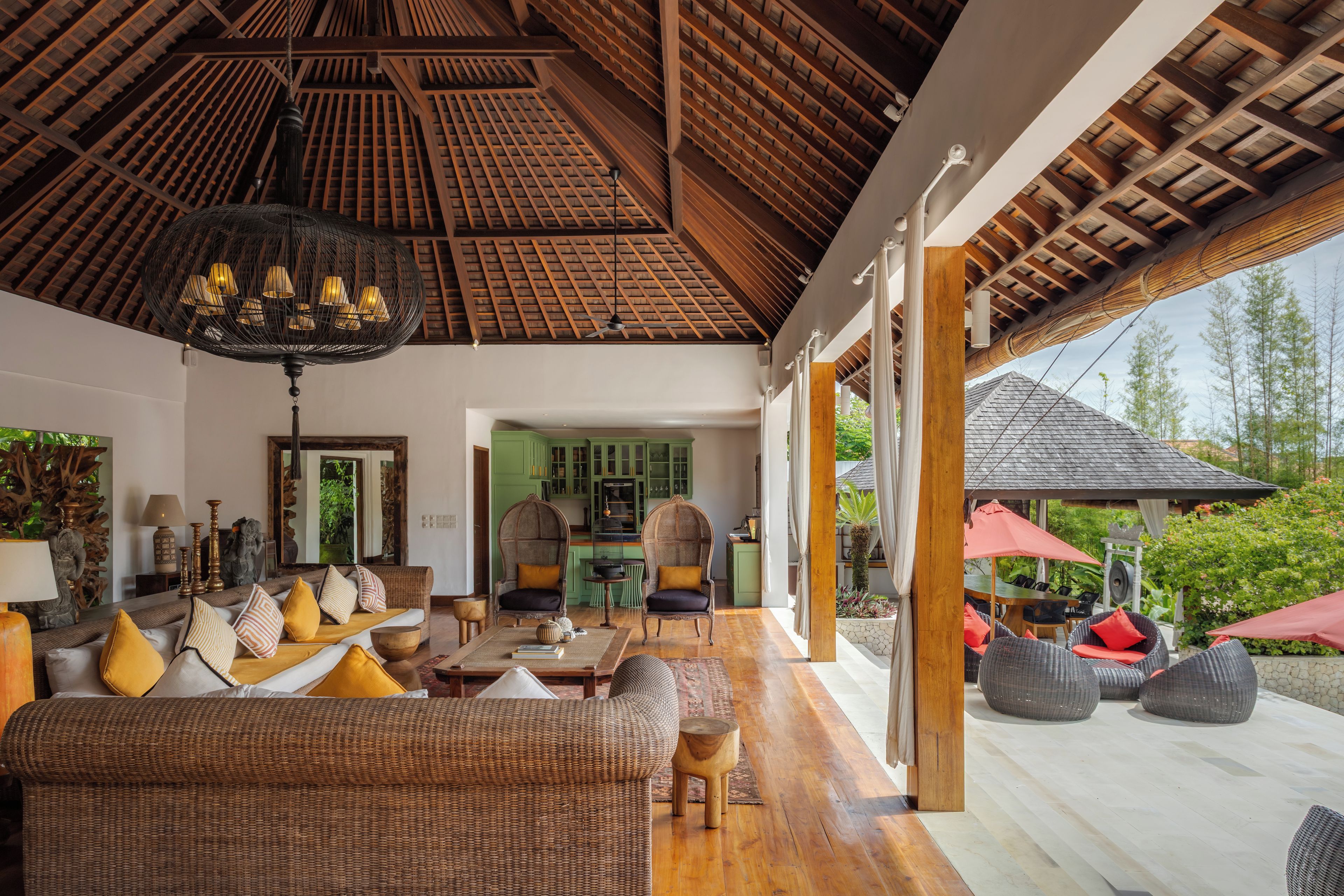 A spacious living area with a high ceiling, a dining area, and a view of the outdoors.