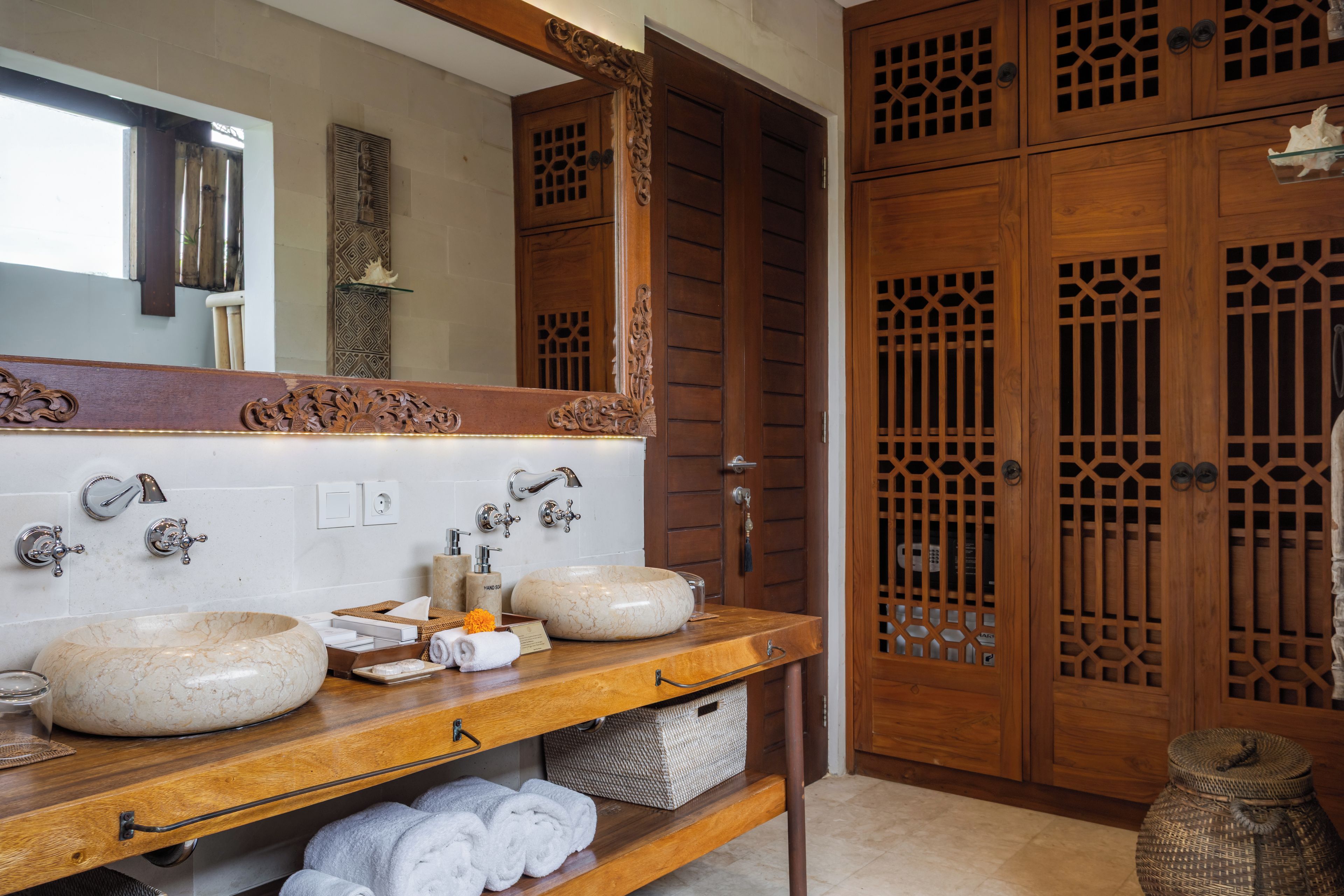 A bathroom with two sinks, a mirror, and wooden cabinets.