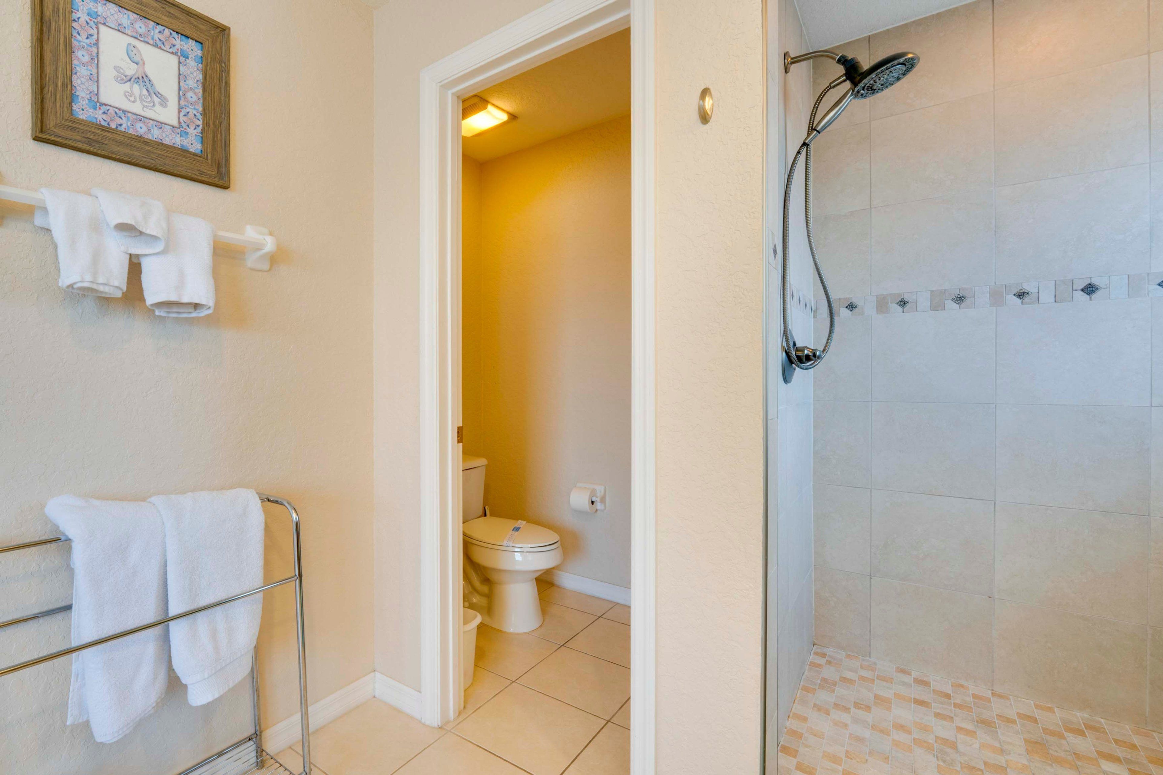 Une salle de bain avec douche, toilettes et porte-serviettes.