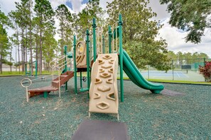 Ein Spielplatz mit Rutsche, Klettergerüsten und einer Wippe.