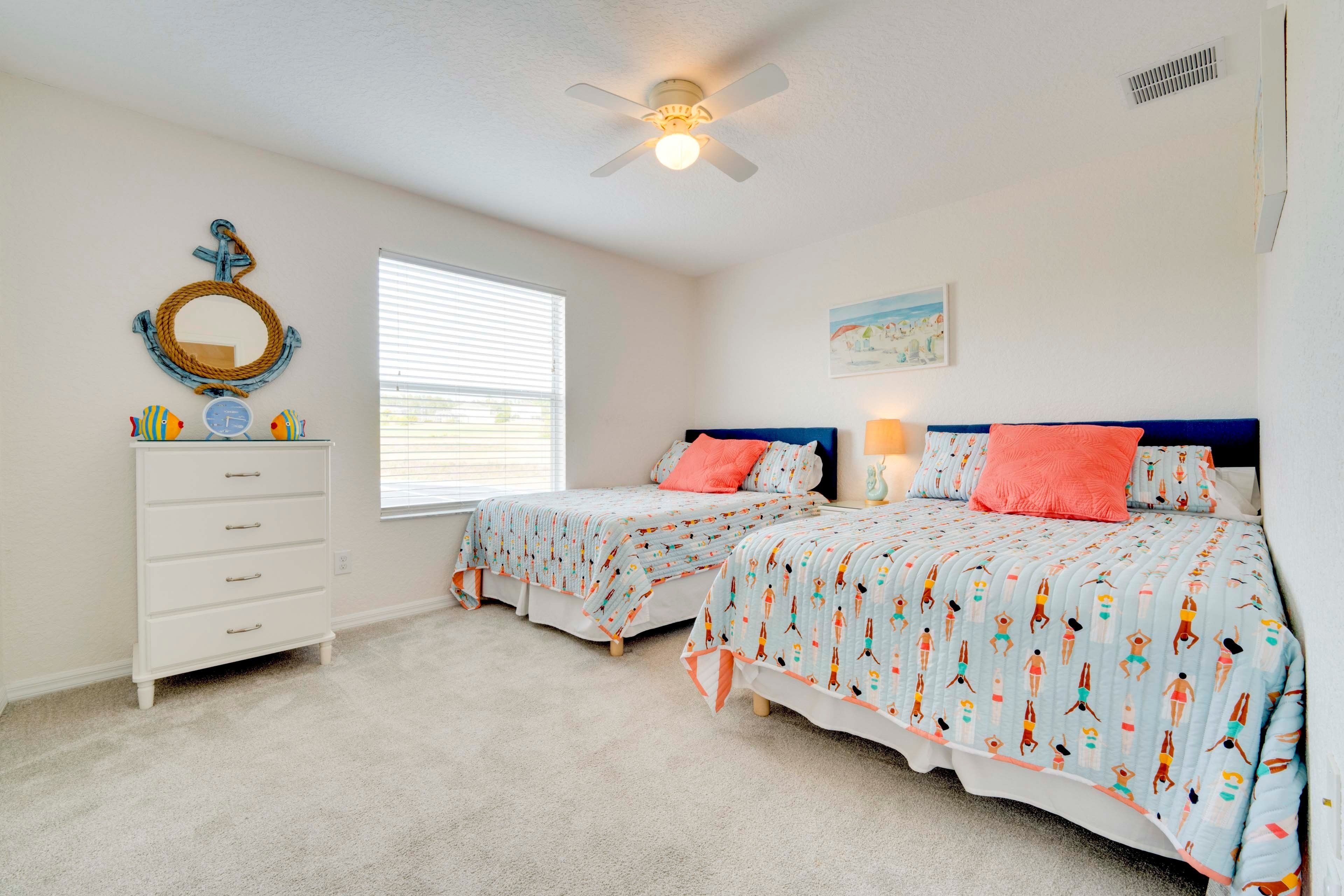 A bedroom with two beds, a dresser, a ceiling fan, a window with blinds, and a wall-mounted mirror.