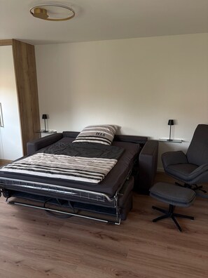 Ein modernes Schlafzimmer mit einem Bett, einem Schreibtisch und einem Stuhl.
