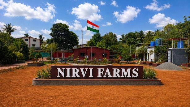 Ein Schild für Nirvi Farms mit einer Flagge im Hintergrund.