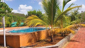 Ein Swimmingpool, umgeben von Palmen und einem Pflasterweg.