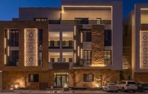 A multi-story hotel with a modern design, featuring balconies and decorative patterns on the facade. - Luxury Residential Serviced Apartments (Riyadh)