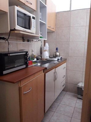 A compact kitchen with a microwave, toaster, and coffee maker. - Alto Palermo Apartment (Buenos Aires)