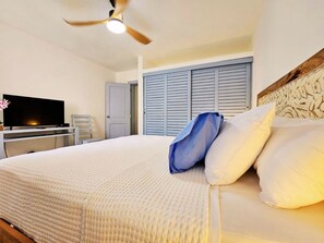 Une chambre d’hôtel équipée d’un lit, d’une télévision, d’un bureau et d’une armoire.