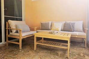 Une pièce comprenant un banc en bois, une table en bois et un canapé avec des coussins.