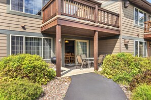 A building with a covered patio area, outdoor seating, and a grill. - Eagle River Chain of Lakes Condo with Indoor Pool (Eagle River)