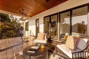 A modern outdoor seating area with a table, chairs, and a ceiling fan. - Eastside Swim - Pool, Spa, Movie Room - Sleeps 13 (Austin)