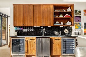 A kitchen with wooden cabinets, a black countertop, and stainless steel appliances. - Eastside Swim - Pool, Spa, Movie Room - Sleeps 13 (Austin)