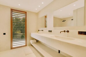A modern bathroom with a large mirror, two sinks, and a shower. - Kas Secreto – An Exclusive Oceanfront Escape Villa in Bonaire (Kralendijk)
