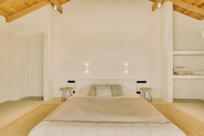 A bedroom with a large bed, two bedside tables, a headboard, and a wooden ceiling. - Kas Secreto – An Exclusive Oceanfront Escape Villa in Bonaire (Kralendijk)