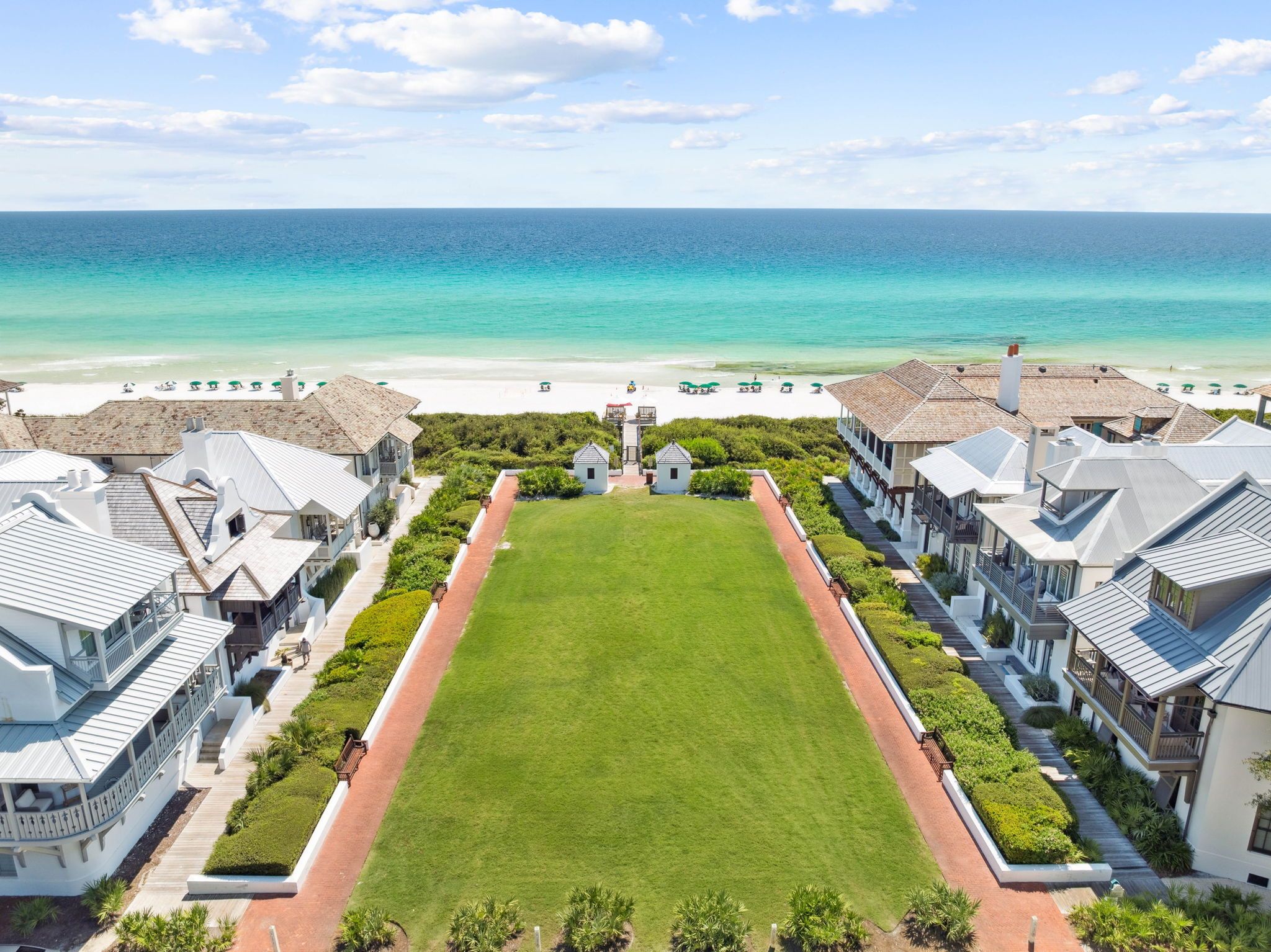 Ein Resort mit einer großen Liegewiese, Strandvillen und Blick auf den Ozean.