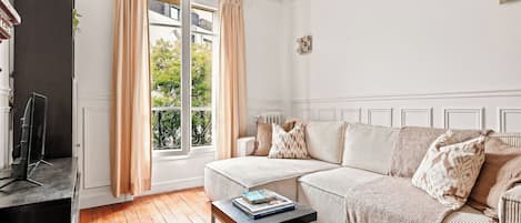 A living room with a sofa, a coffee table, and a television.