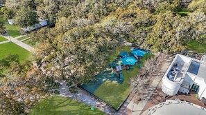 An aerial view of a park with a playground, a swimming pool, and a building with a dome roof. - Charming Victorian 2BR Near Forsyth (Savannah)