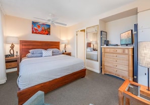 A hotel room with a large bed, a dresser, a television, and a ceiling fan. - Mana Kai 310: 2  BR, 2  BA Condominium in Kihei, Sleeps 4 (Kihei)