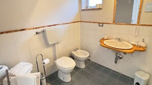 A bathroom with a toilet, bidet, sink, and a mirror. - Ca' San Sebastiano Wine Resort & Spa 2 (Castel San Pietro)