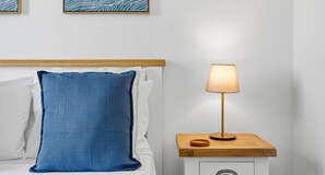 A bed with a blue pillow and a bedside table with a lamp. - Junior Villa EZ02 - Minimi (Kouklia)