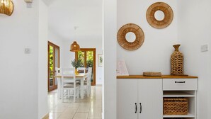 A hallway with a dining area, white walls, and a wooden cabinet with woven baskets. - Junior Villa EZ02 - Minimi (Kouklia)