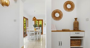 A hallway with a dining area, white walls, and a wooden cabinet with woven baskets. - Junior Villa EZ02 - Minimi (Kouklia)