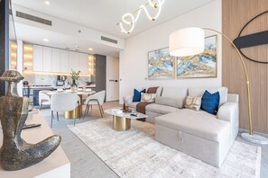 A modern living room with a sofa, coffee table, and decorative items. - 40th+ Floor 1BR w/ Burj Khalifa & Canal Views, Spacious Balcony, Near Downtown (Dubai)