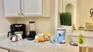 A kitchen counter with a coffee maker, blender, paper towels, snacks, and cleaning supplies. - Ref 519. 5 Bedroom villa own pool/spa. Recent refurb. Disney (Osceola County)