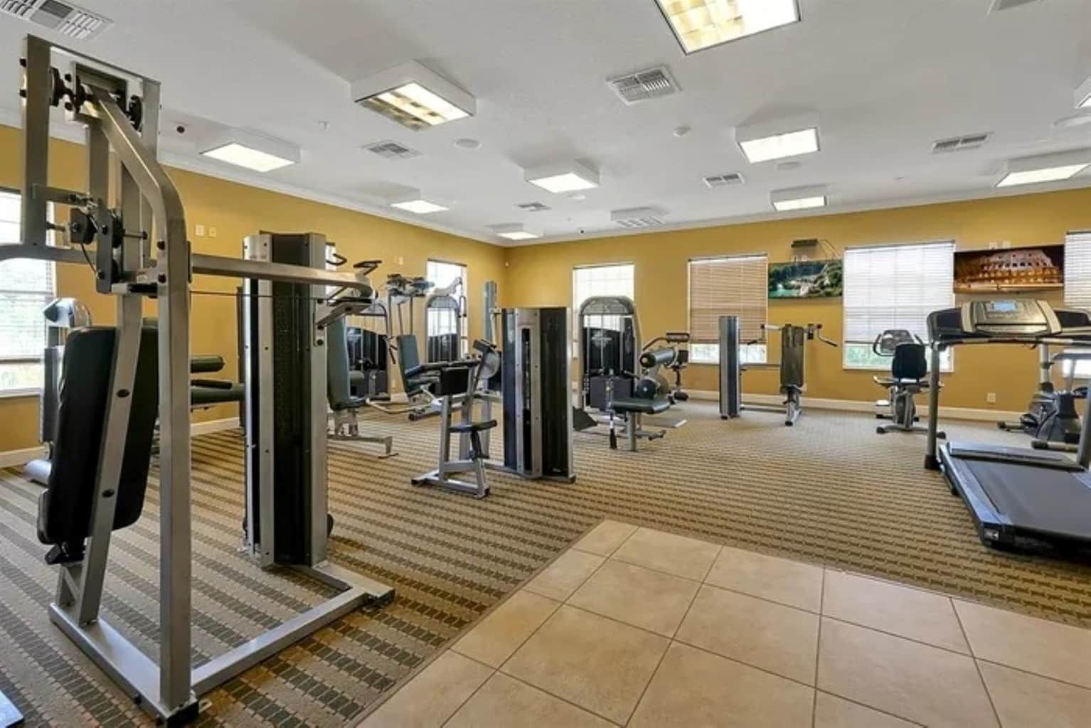 Ein Fitnessstudio mit verschiedenen Trainingsgeräten, darunter Kraft- und Ausdauergeräte.