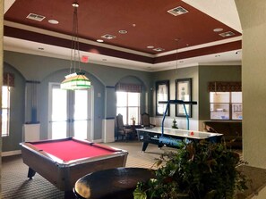 A pool table with a red felt surface, a billiards table, and a hanging lamp in a room with a high ceiling and arched doorways. - Ref 519. 5 Bedroom villa own pool/spa. Recent refurb. Disney (Osceola County)