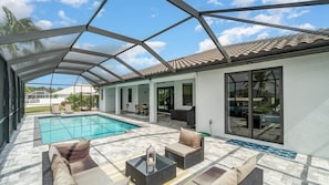 A covered outdoor area with a pool, seating, and a view of the surrounding landscape. - Ref 426. 4 Bedromm Cape Coral waterfront villa. Own pool (Cape Coral)