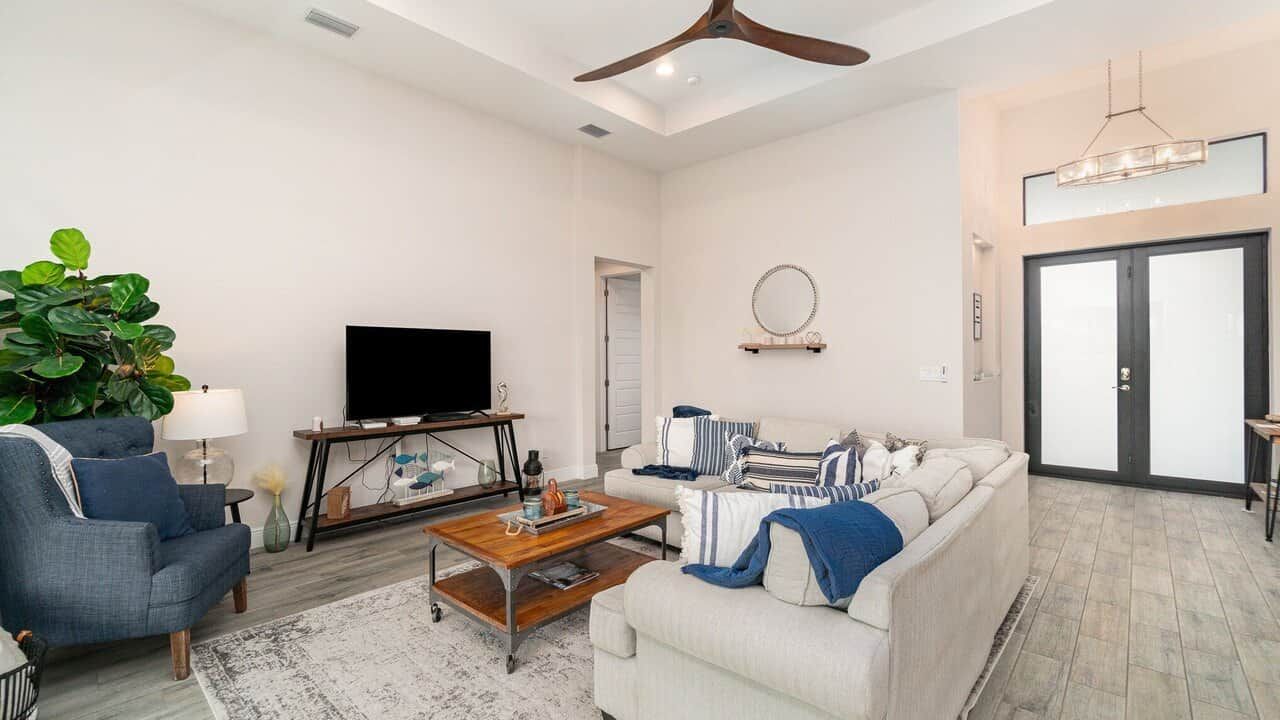 A modern living room with a sofa, armchair, coffee table, and a television.