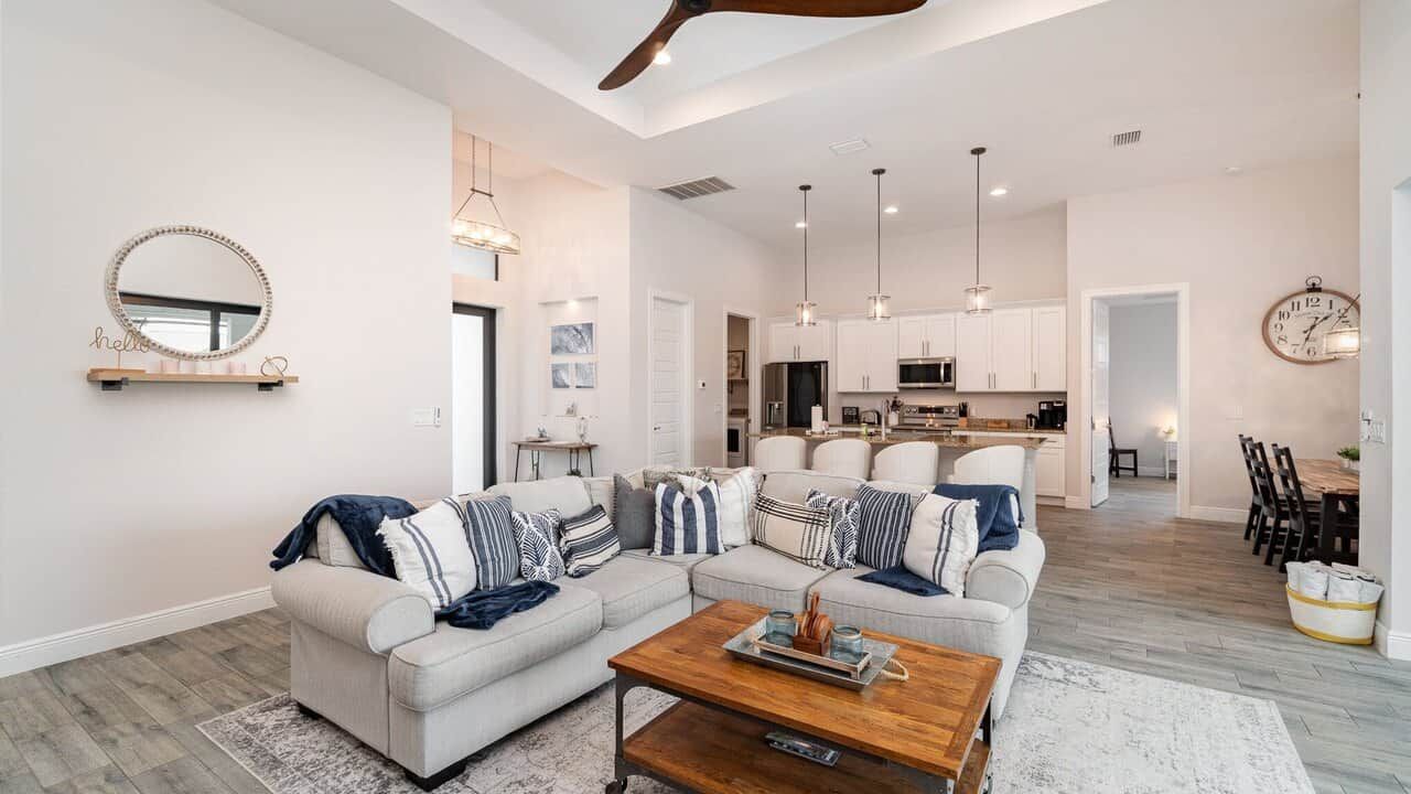A modern living room with a sofa set, a coffee table, and a dining area with chairs.