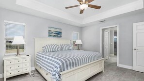 A bedroom with a bed, nightstands, a ceiling fan, and a door leading to another room. - Ref 901. Cape Coral villa, free heated pool. Pet friendly (Cape Coral)