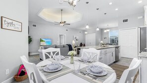 A modern kitchen with white cabinets, a built-in oven, and a dining area with a table set for four. - Ref 901. Cape Coral villa, free heated pool. Pet friendly (Cape Coral)
