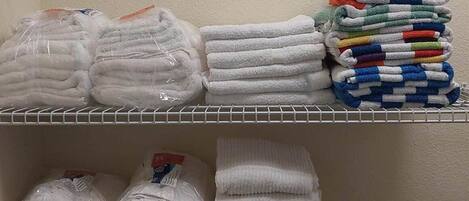 Une étagère de rangement contenant des serviettes et du linge de bain.